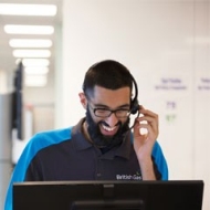 Smiling man British Gas agent on phone - business electricity prices, rates, suppliers